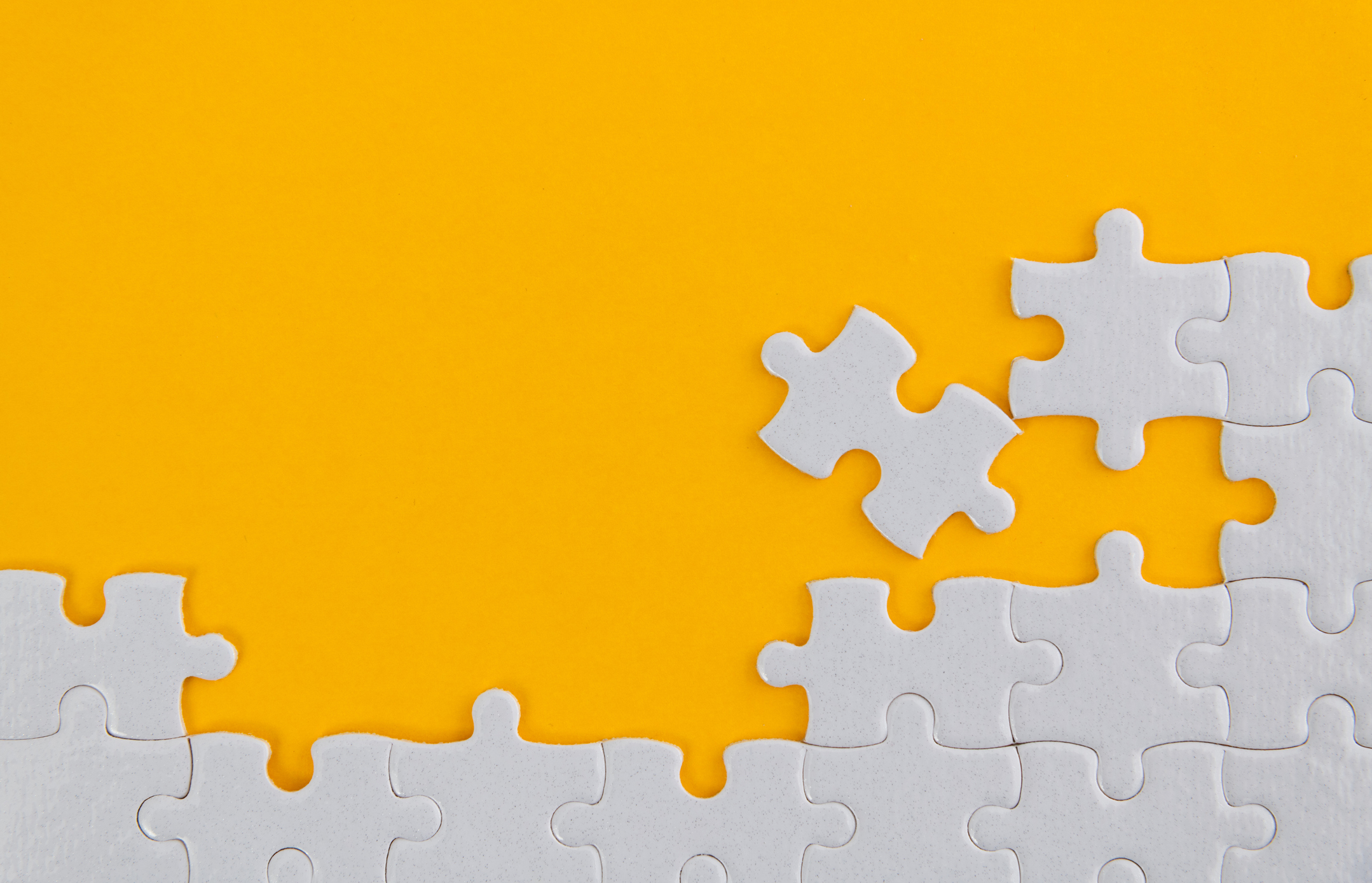 White jigsaw puzzle on yellow background